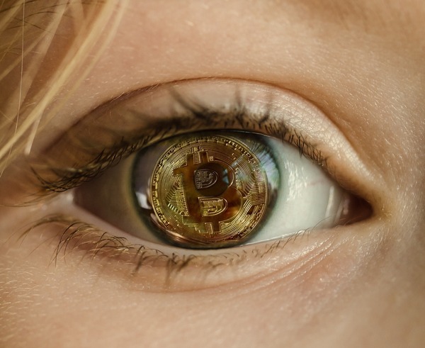 Close-up of an eye reflecting a bitcoin