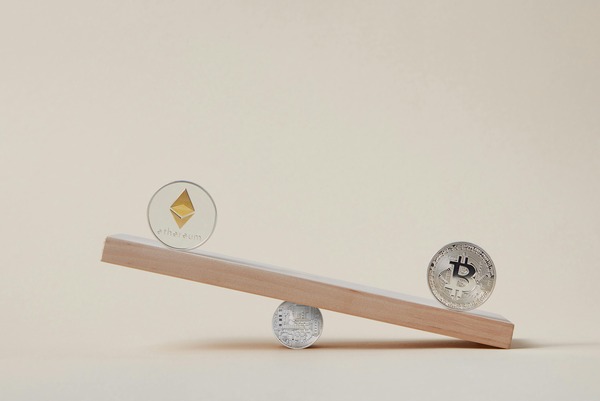 Ethereum and bitcoin coins balanced on a seesaw