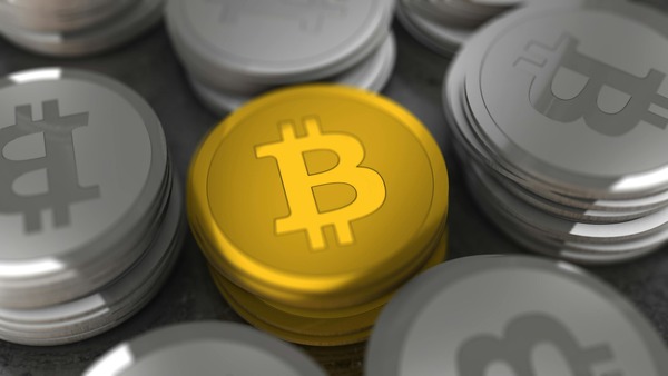 Gold bitcoin among silver coins