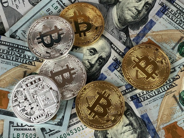 Bitcoin coins scattered over dollar bills