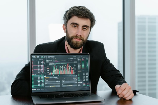 Man presenting a trading chart on a laptop