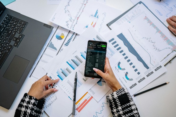 Hands analysing charts with a smartphone