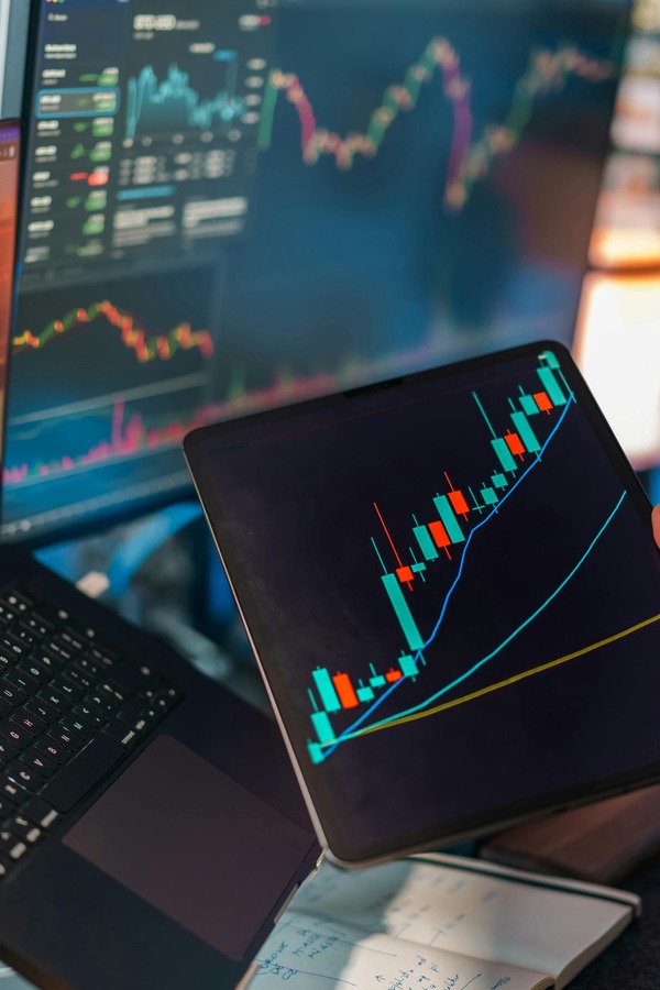 Tablet with a trading chart on a laptop
