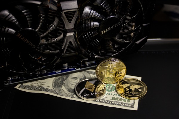 Crypto coins on dollar bills by a graphics card