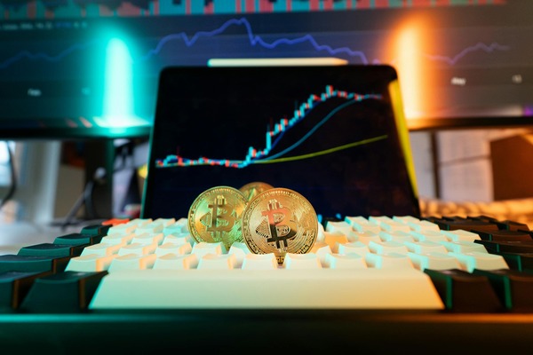 Bitcoin coins on a keyboard in front of a chart