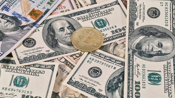 Crypto coin lying on us dollar banknotes