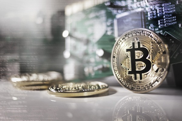 Silver bitcoin coin on a reflective desk
