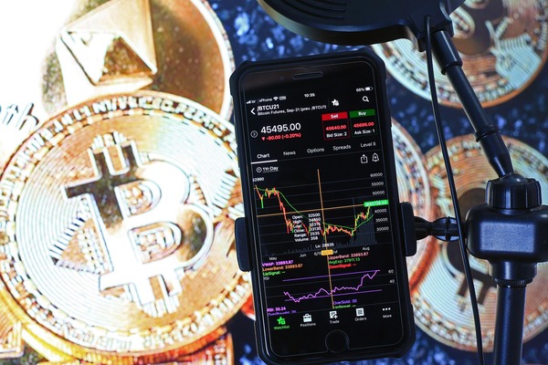 Bitcoin coin with a phone showing a chart