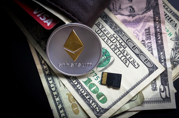 Ethereum coin on dollar bills in a wallet