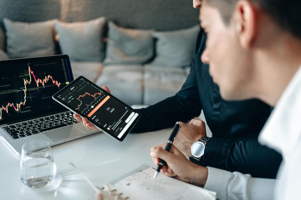 Two people reviewing charts on a laptop and phone