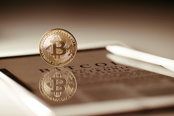 Bitcoin coin reflected on a tablet