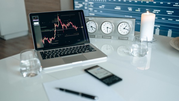 Laptop with a price chart on a white desk