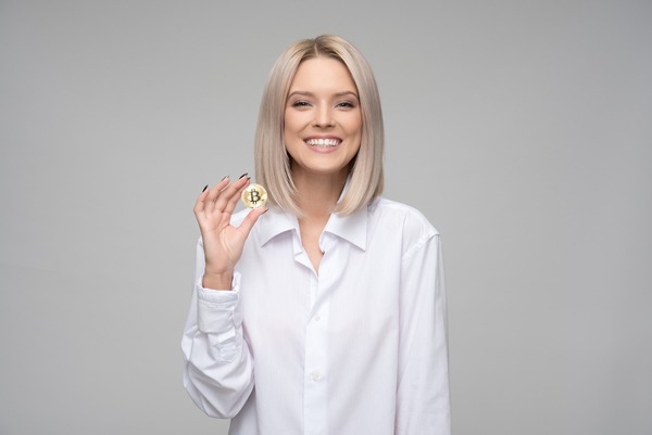Smiling woman holding a crypto coin
