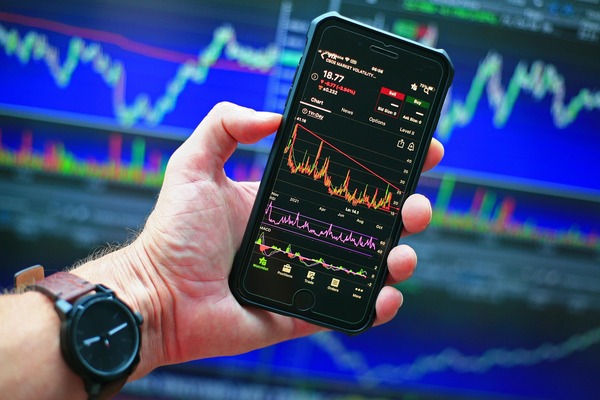 Hand holding a phone with a market chart